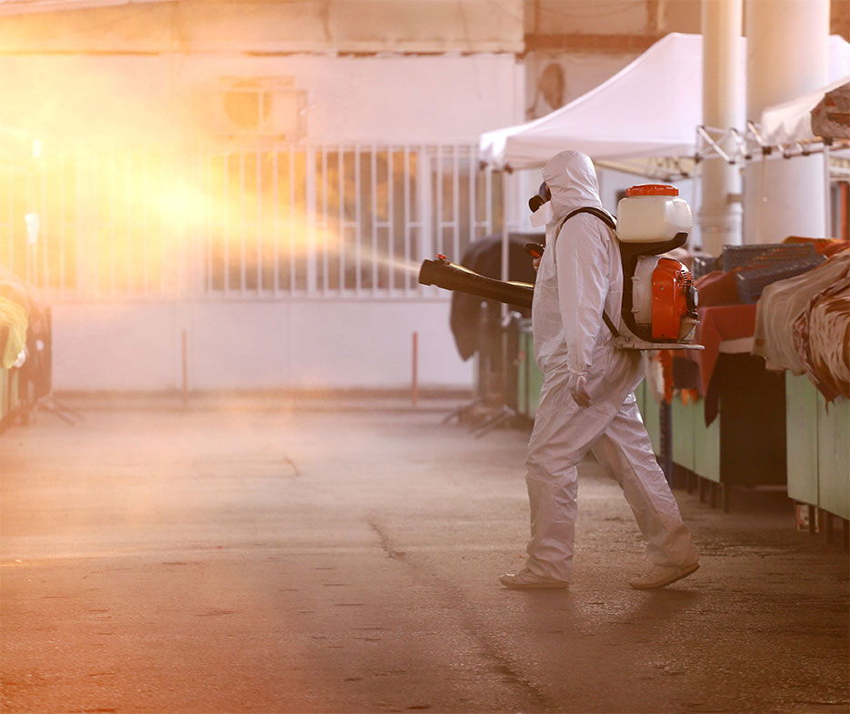 Man performs coronavirus cleaning services inside an industrial plant